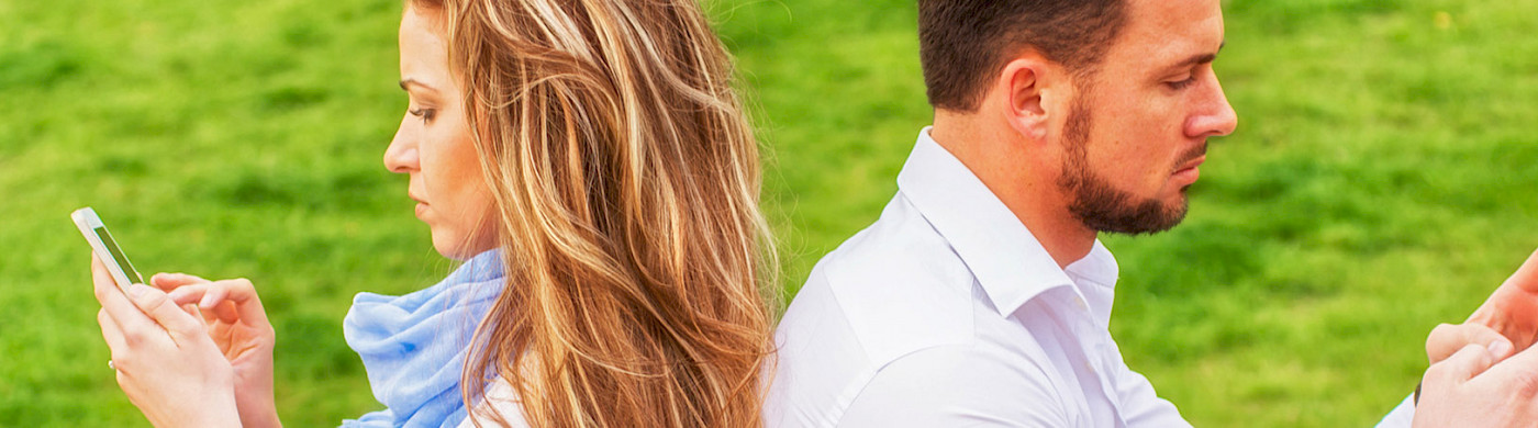 Man und Frau - Rücken an Rücken, ins Handy starrend - © 