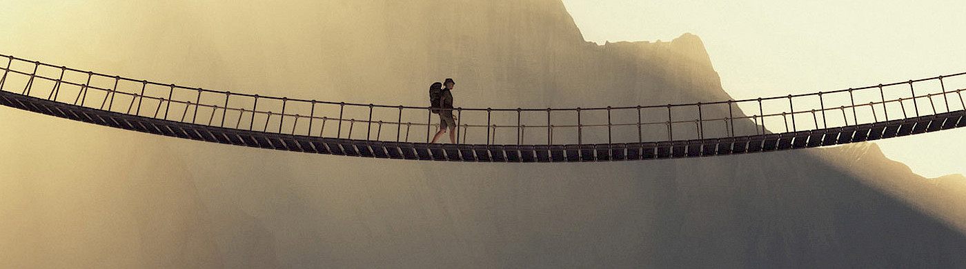 Mann mit Rucksack geht über eine Hängebrücke - © 